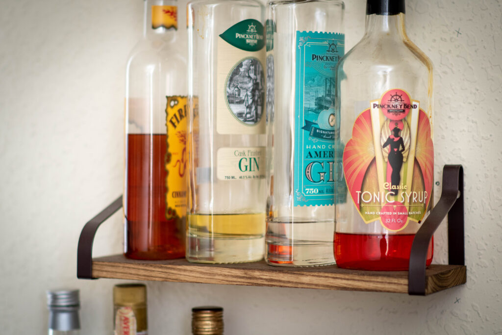 Photo of a small shelf holding various liquors.