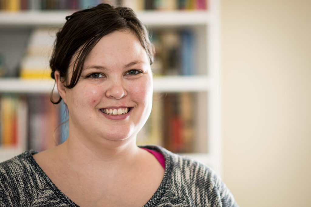 Portrait of a woman standing in front of a bookcase