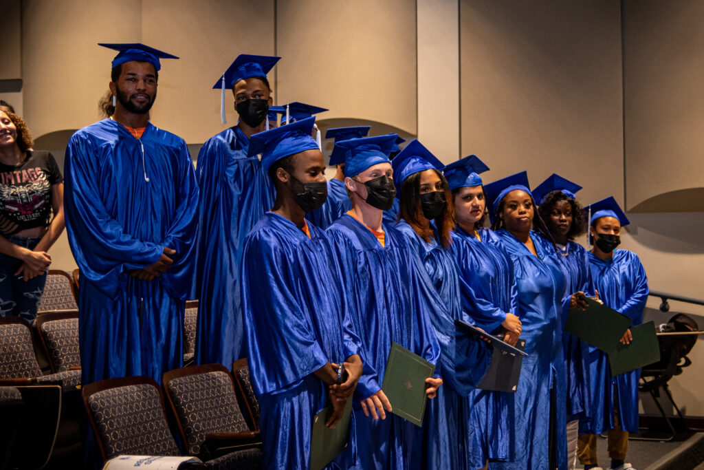 Students stand to be honored at Summer 2022 graduation.