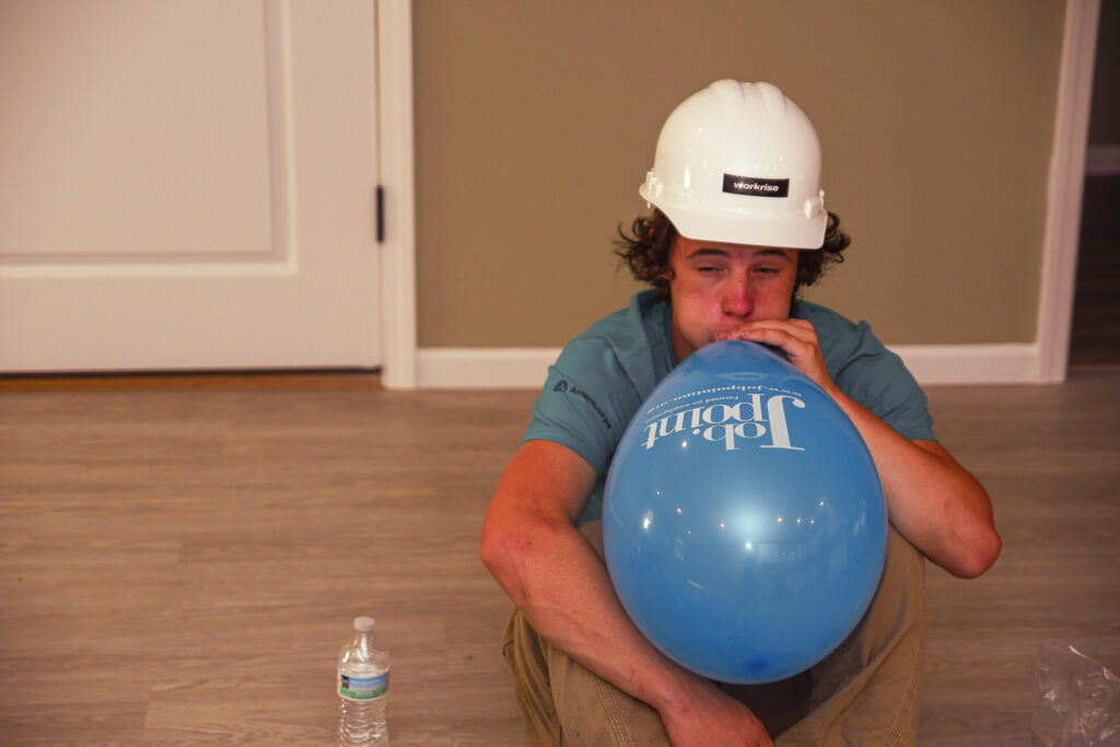 student blows up a balloon in preparation for the celebration.