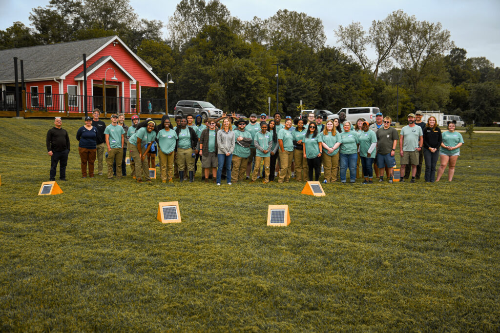 a large group of students from Job Point's YouthBuild program stand with staff and volunteers from Missouri River Relief.